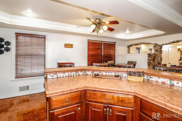 a view of a kitchen with kitchen island a large window cabinets a sink and stainless steel appliances