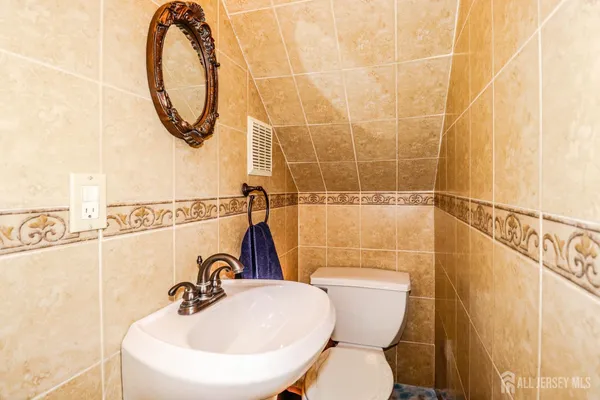 a bathroom with a sink a toilet and a mirror