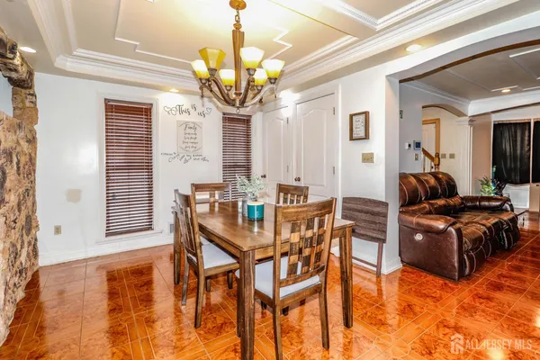 a living room with dining table and a chandelier