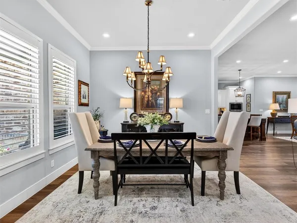 a dining room with furniture a chandelier and wooden floor