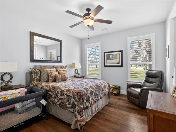 a bedroom with a bed couches and wooden floor