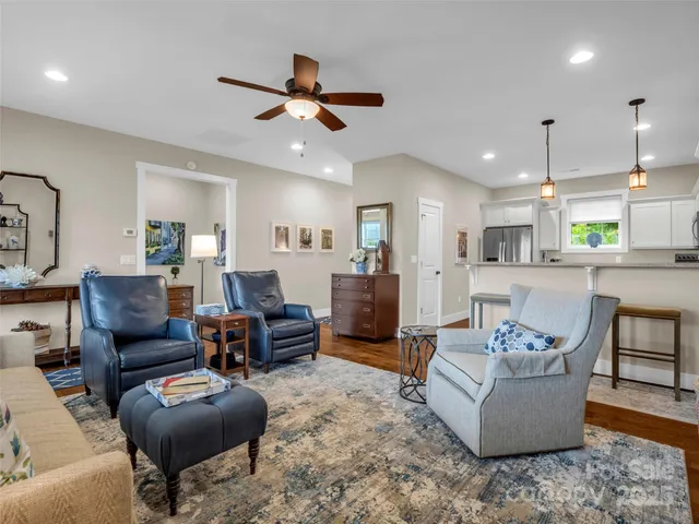 a living room with furniture kitchen view and a chandelier