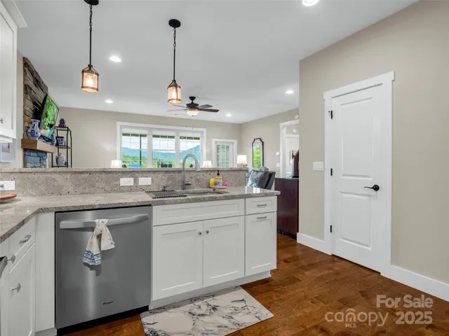 a kitchen with stainless steel appliances granite countertop a sink a stove a refrigerator and island with wooden floor