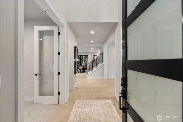 a view of a hallway with wooden floor and staircase