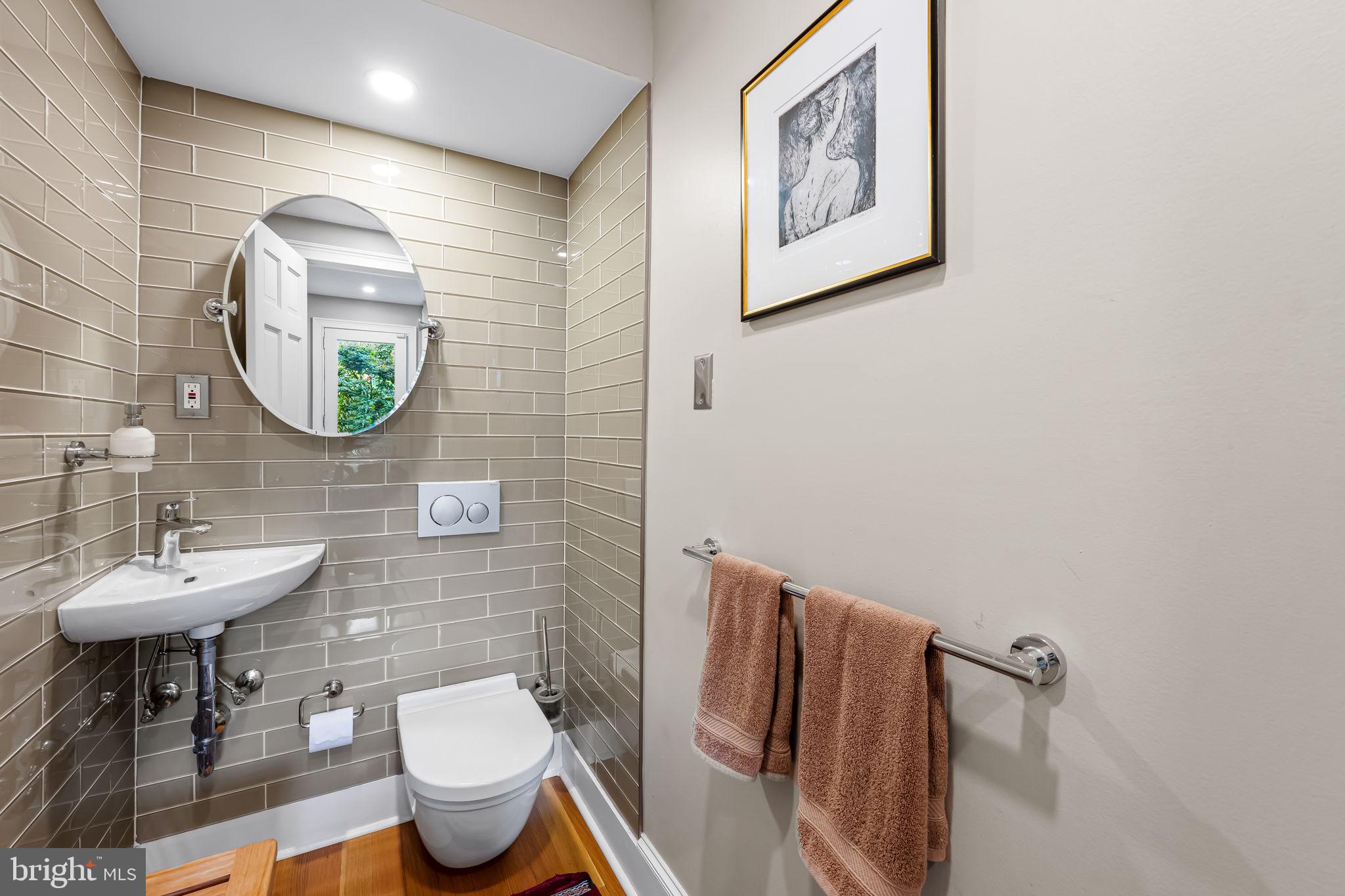 1310 Bolton Street Baltimore, MD 21217 - Photo 28 of 69 a bathroom with a toilet sink and mirror