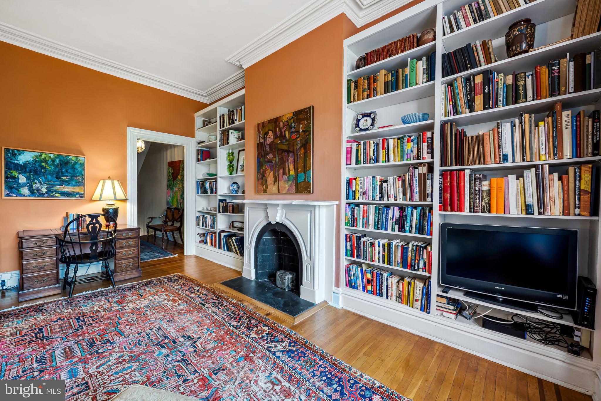 1310 Bolton Street Baltimore, MD 21217 - Photo 34 of 69 a living room with bookshelf and a fireplace