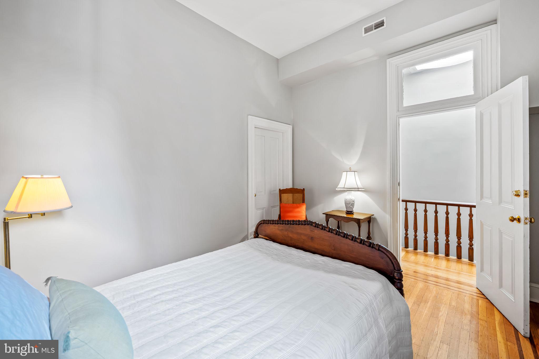 1310 Bolton Street Baltimore, MD 21217 - Photo 50 of 69 a bedroom with a bed and a lamp on table