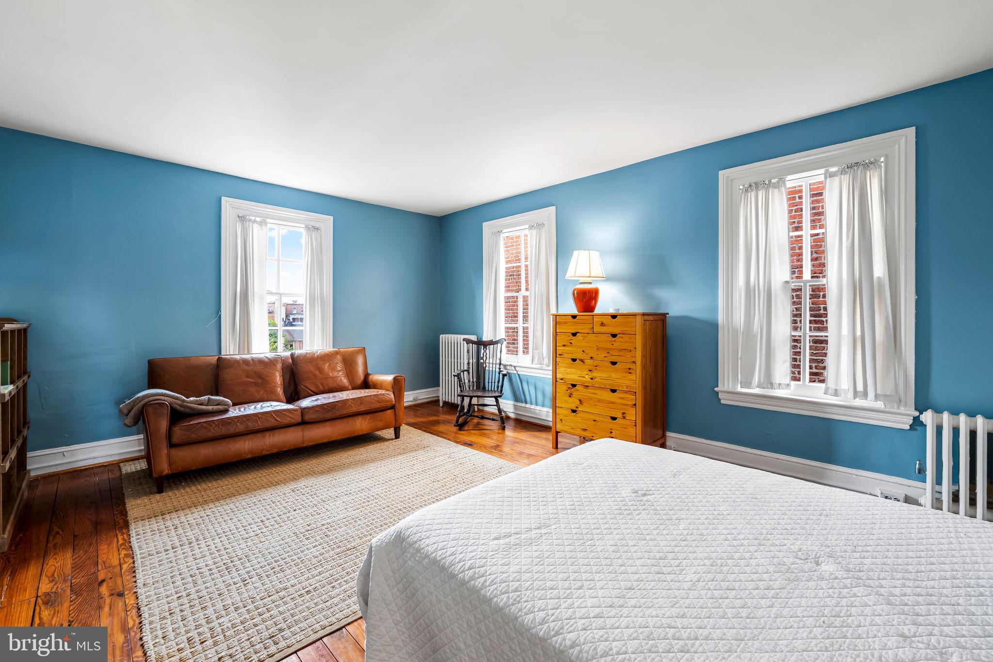 1310 Bolton Street Baltimore, MD 21217 - Photo 51 of 69 a bedroom with a bed and wooden floor