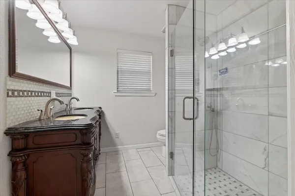 a bathroom with a sink a toilet and shower