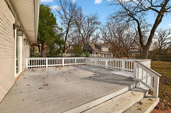 a view of a deck with a large window and wooden fence