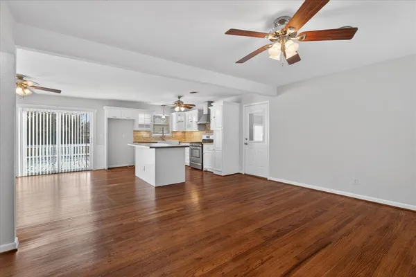 a view of a kitchen with wooden floor and a ceiling fan