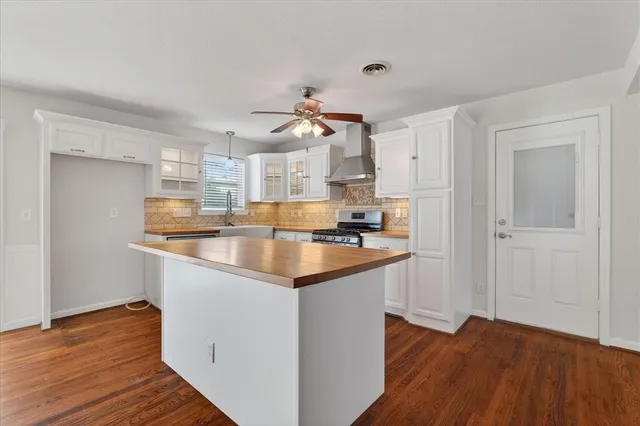 a kitchen with granite countertop a sink cabinets and wooden floor