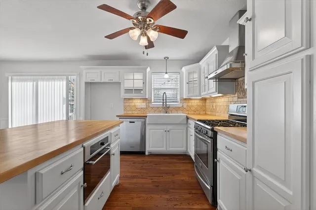 a kitchen with granite countertop cabinets stainless steel appliances a sink and a window