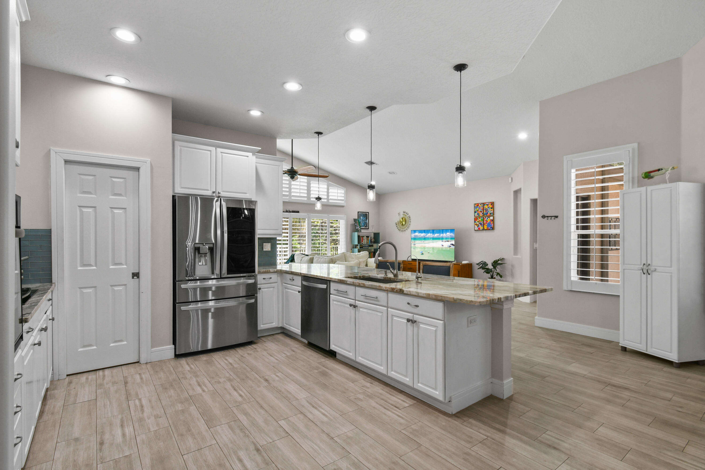 303 Hardwood Point Jupiter, FL 33458 - Photo 22 of 75 a kitchen with stainless steel appliances kitchen island granite countertop a refrigerator a stove oven a sink with island and chairs