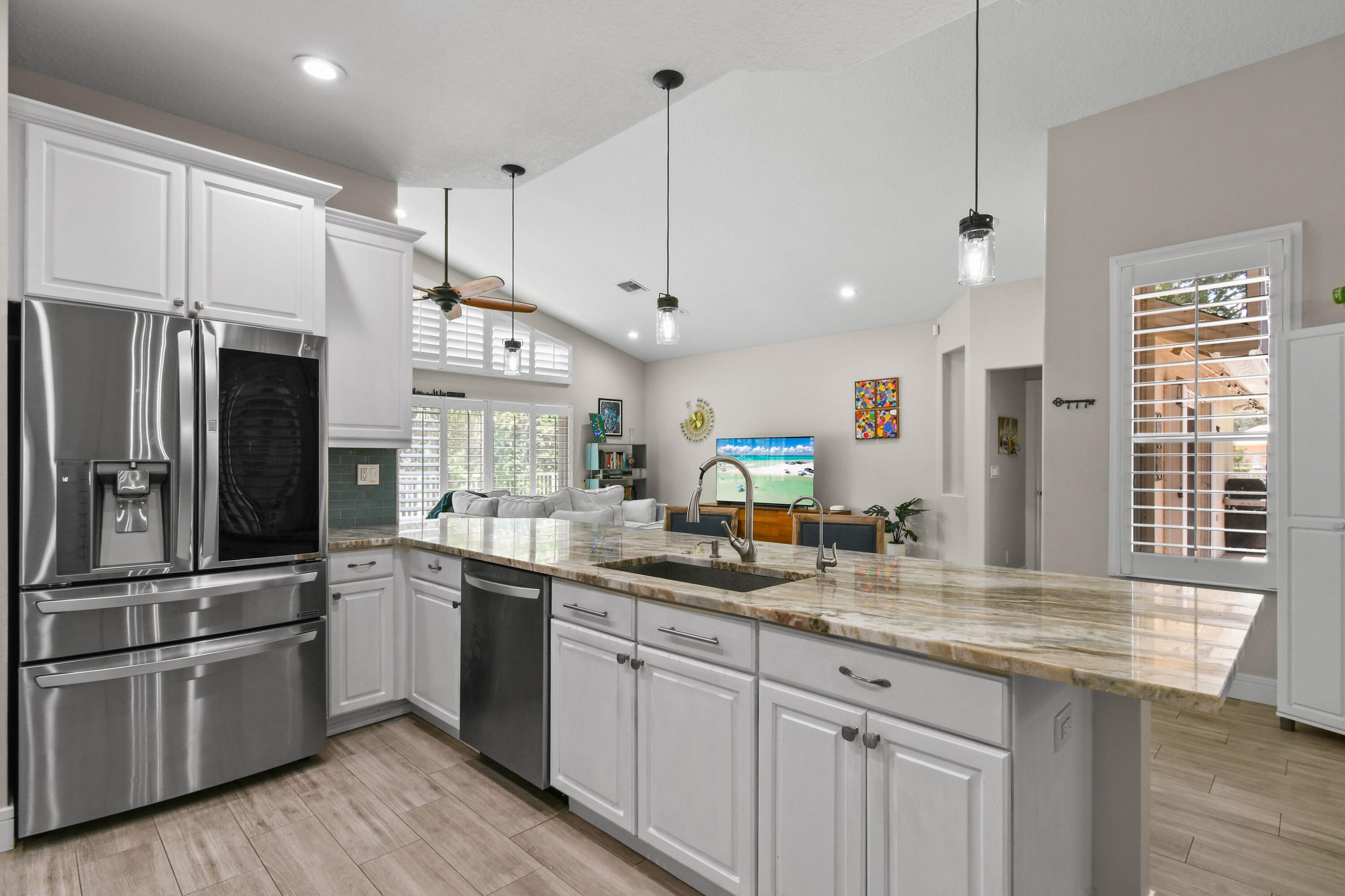 303 Hardwood Point Jupiter, FL 33458 - Photo 24 of 75 a kitchen with stainless steel appliances granite countertop a sink refrigerator and cabinets