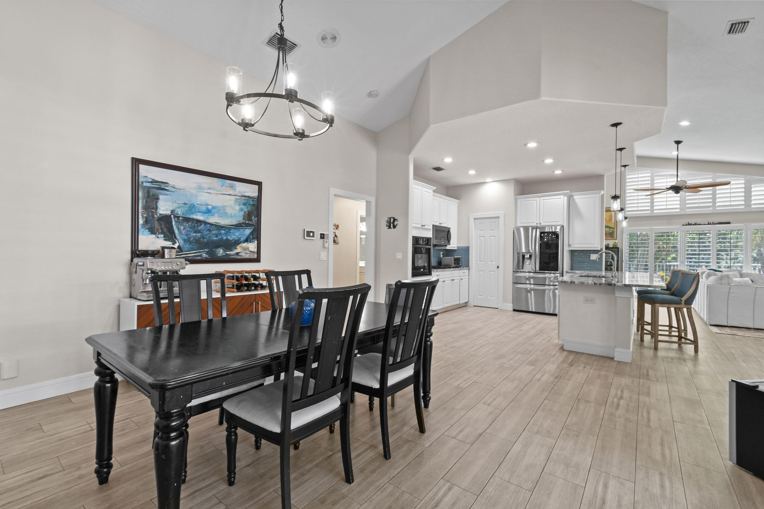 303 Hardwood Point Jupiter, FL 33458 - Photo 27 of 75 a dining room with wooden floor a chandelier a wooden table and chairs