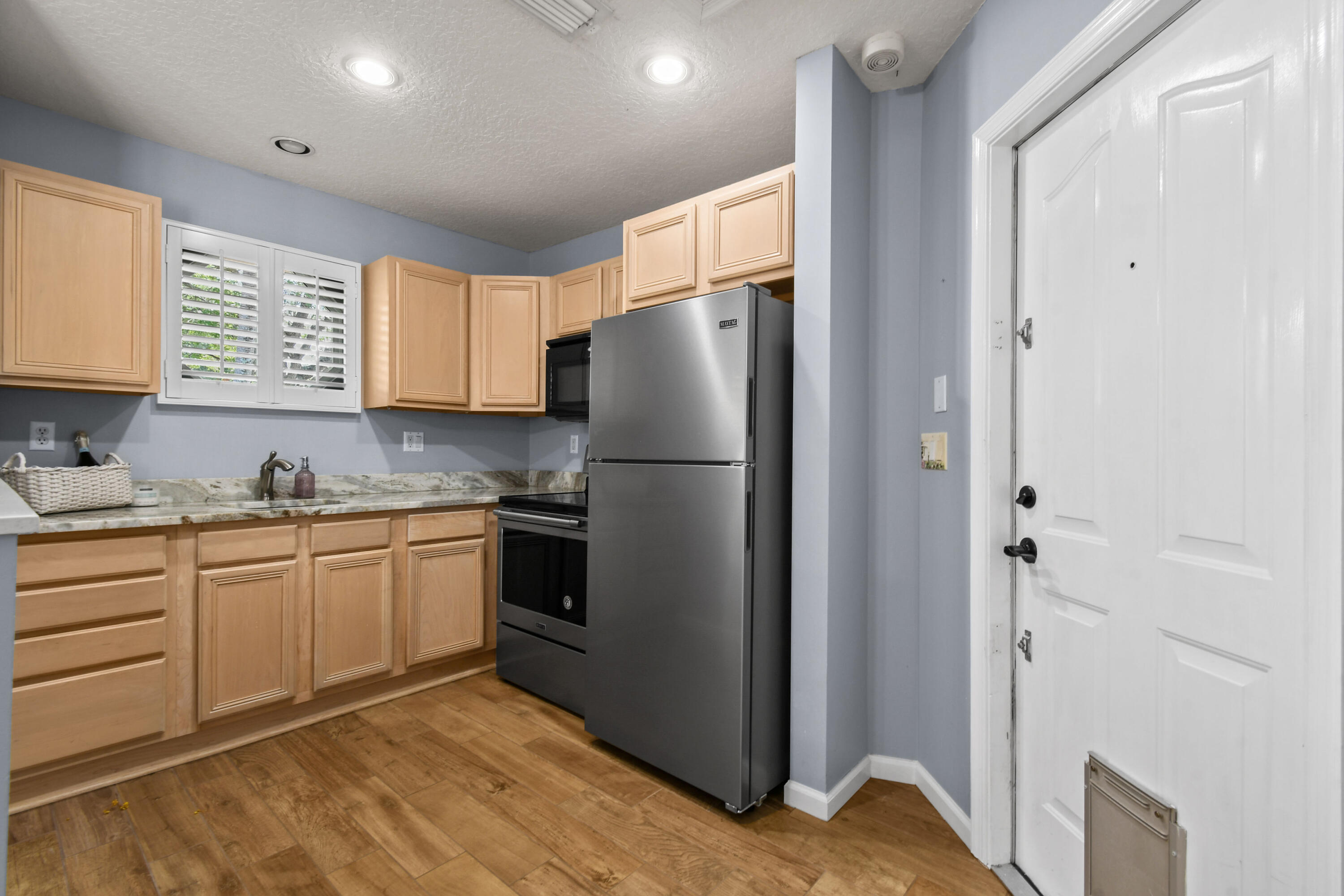 303 Hardwood Point Jupiter, FL 33458 - Photo 44 of 75 a kitchen with stainless steel appliances granite countertop a refrigerator sink and cabinets