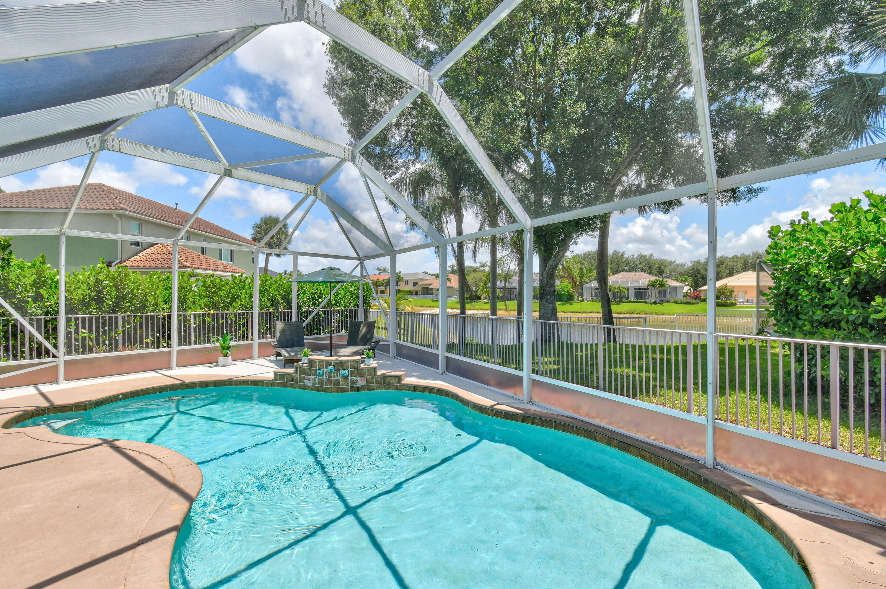 303 Hardwood Point Jupiter, FL 33458 - Photo 6 of 75 a view of a backyard with couches under an umbrella