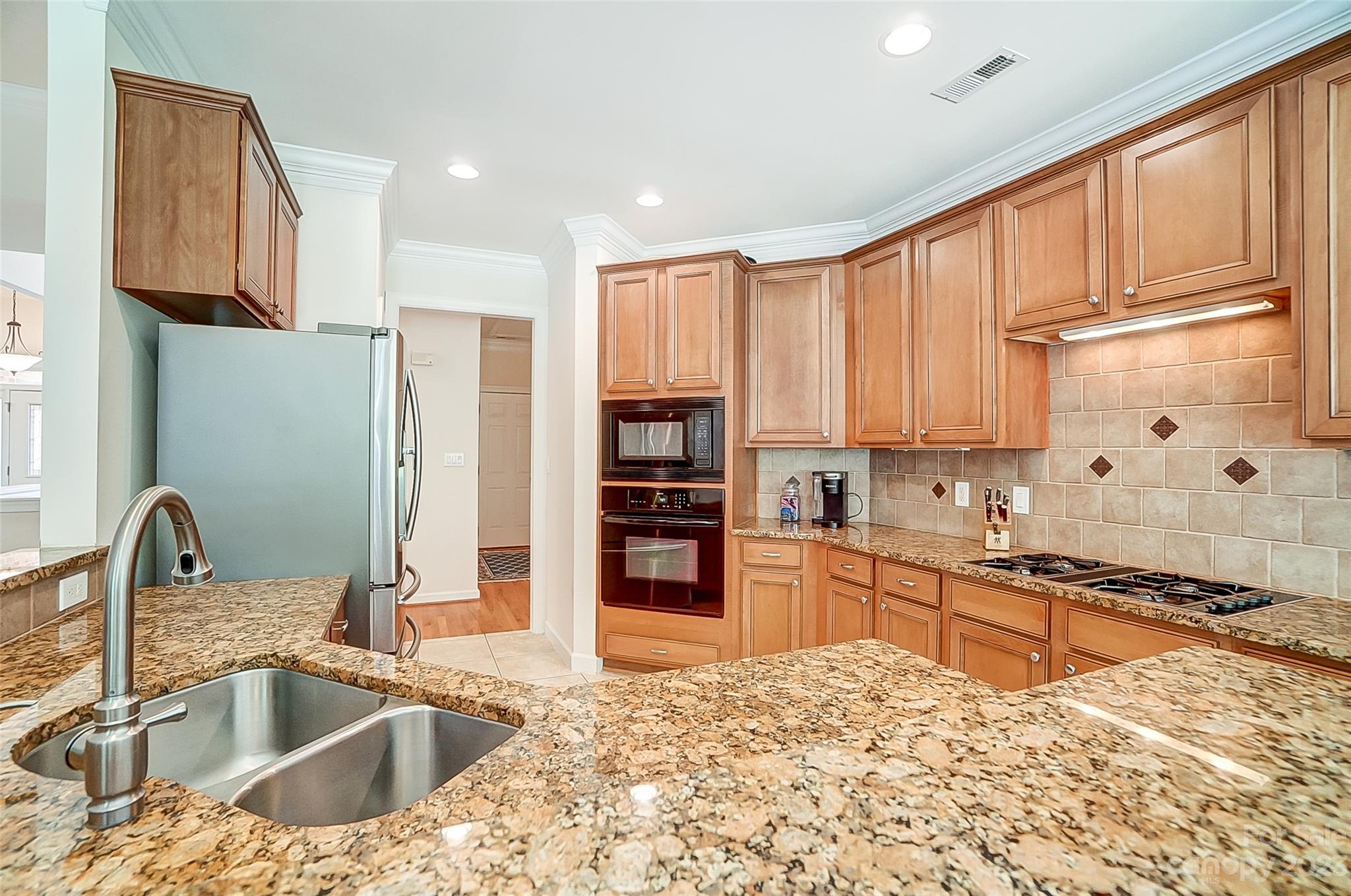 203 Shoreline Parkway Tega Cay, SC 29708 - Photo 14 of 42 a kitchen with stainless steel appliances granite countertop a sink stove and refrigerator