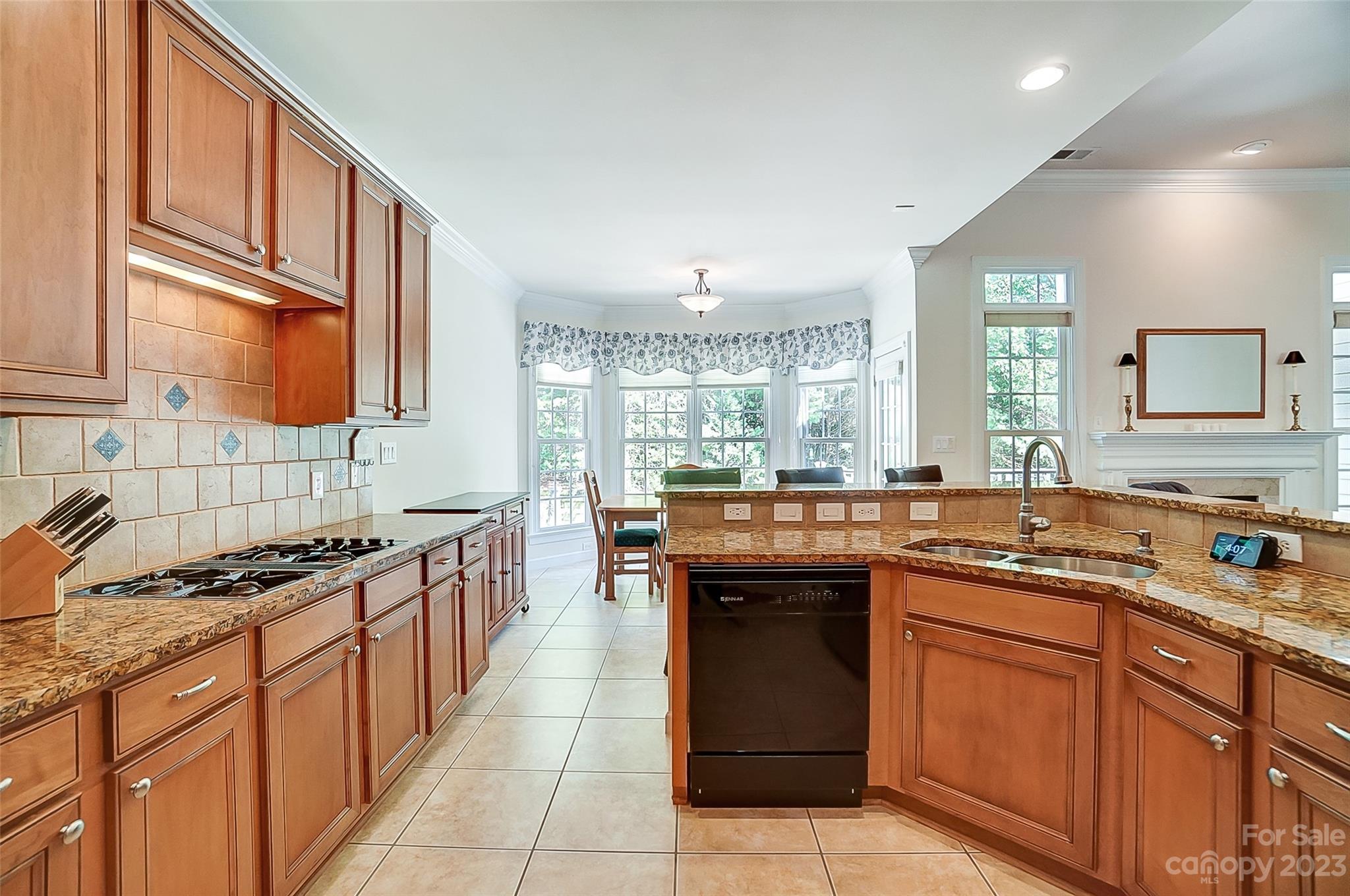 203 Shoreline Parkway Tega Cay, SC 29708 - Photo 17 of 42 a kitchen with kitchen island granite countertop a sink stove top oven and cabinets