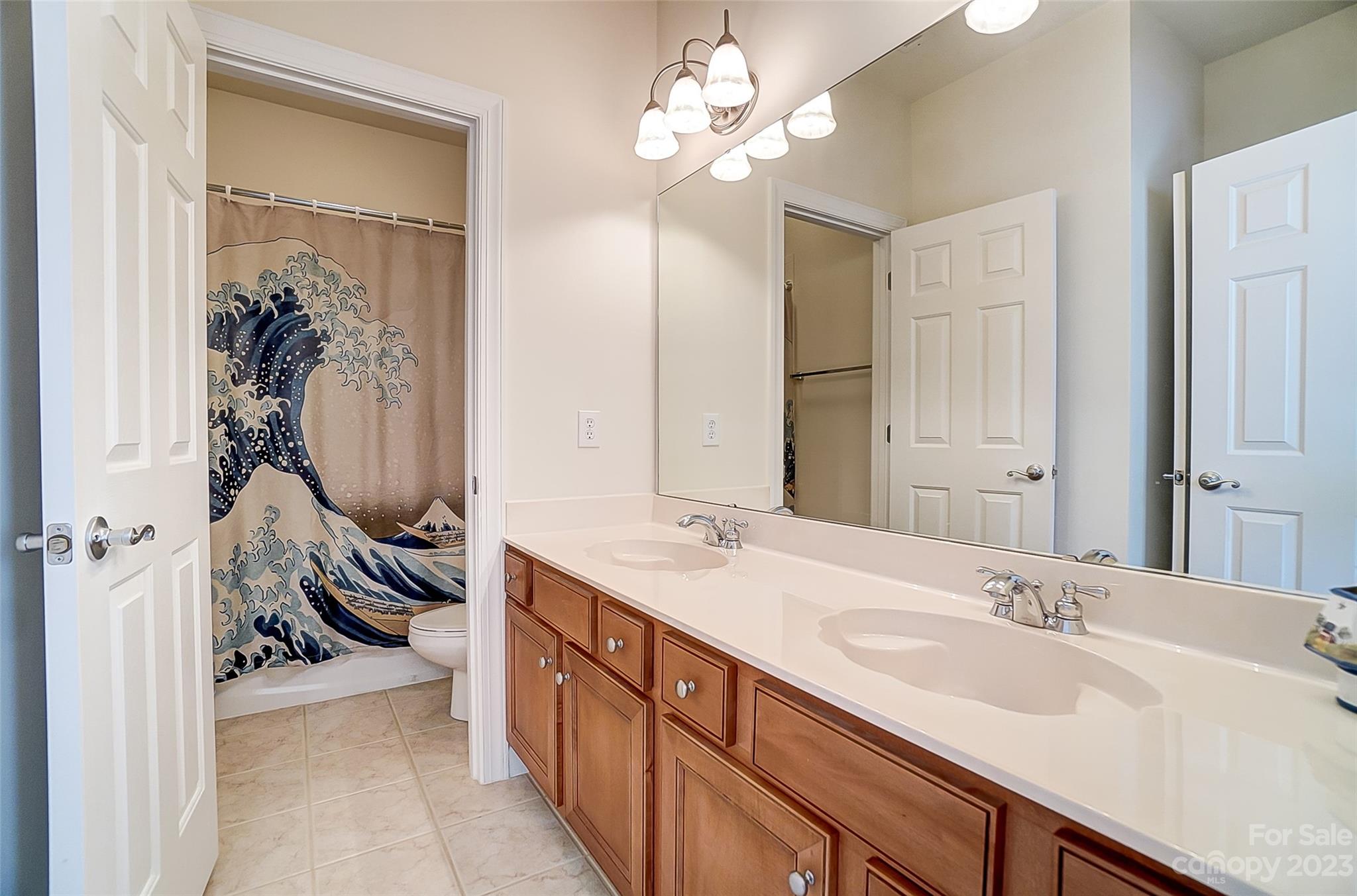 203 Shoreline Parkway Tega Cay, SC 29708 - Photo 32 of 42 a en suite bathroom with a double vanity sink a large mirror and a shower