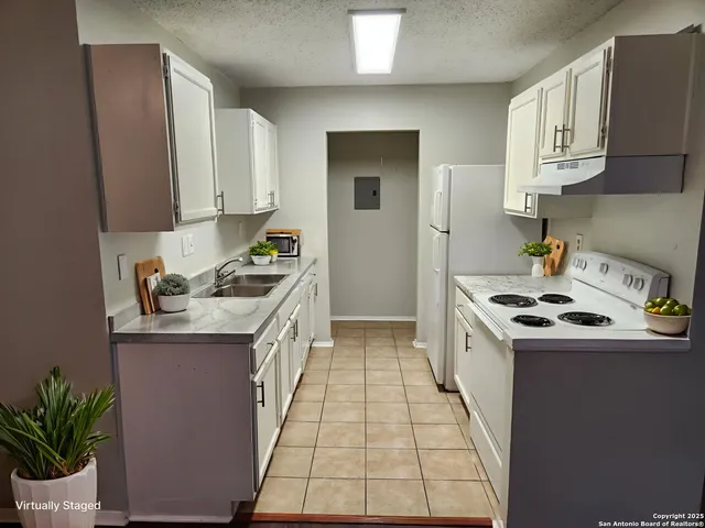 a kitchen with granite countertop a sink stove and cabinets