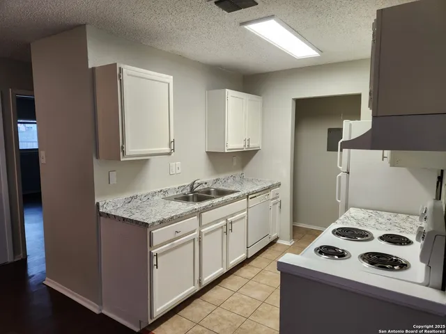 a kitchen with a sink stove top oven and cabinets