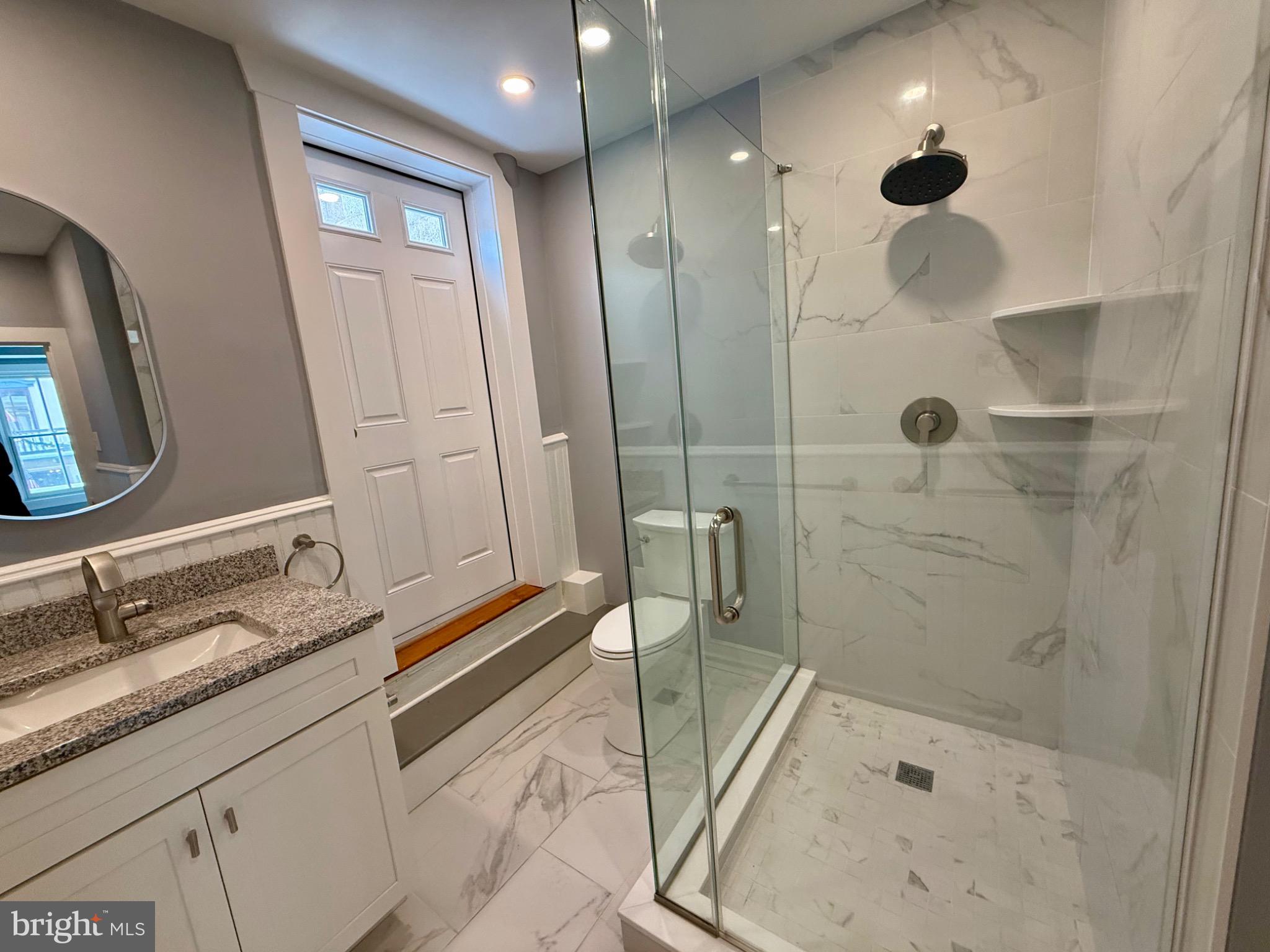 25 West State Street Doylestown, PA 18901 - Photo 6 of 9 a bathroom with a granite countertop sink a mirror and shower