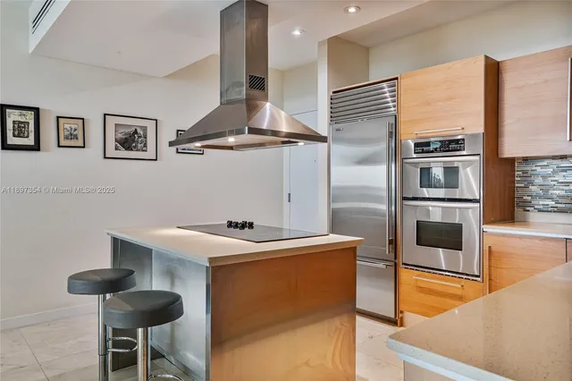 a kitchen with stainless steel appliances granite countertop a sink and a refrigerator