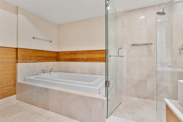 a bathroom with a tub sink shower and mirror