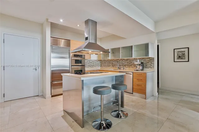 a kitchen with stainless steel appliances granite countertop a sink and a refrigerator