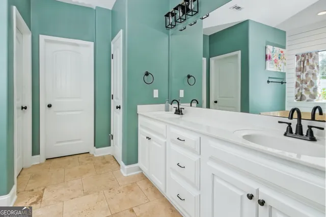 a bathroom with double vanity sink and a mirror