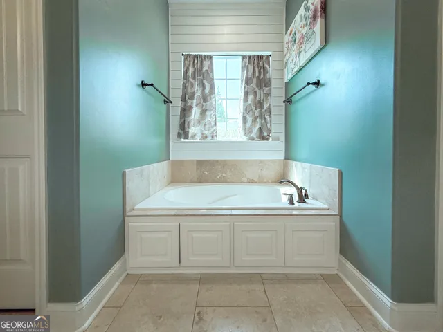 a bathroom with a tub sink and mirror