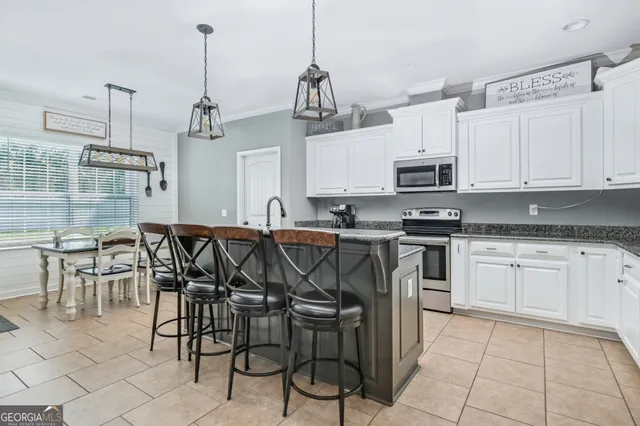 a kitchen with stainless steel appliances granite countertop a stove a sink a microwave and a refrigerator