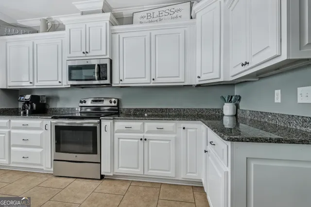 a kitchen with stainless steel appliances granite countertop white cabinets granite counter tops and a sink