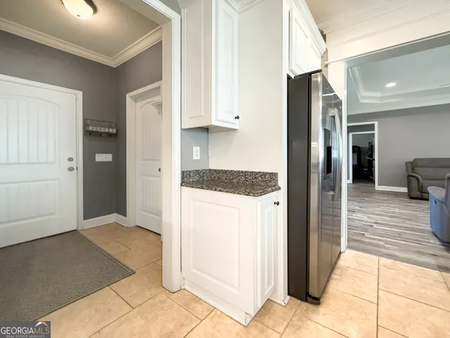 a view of hallway with furniture and a refrigerator