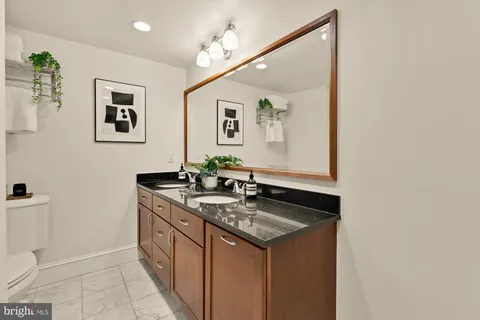 a bathroom with a sink a toilet and mirror