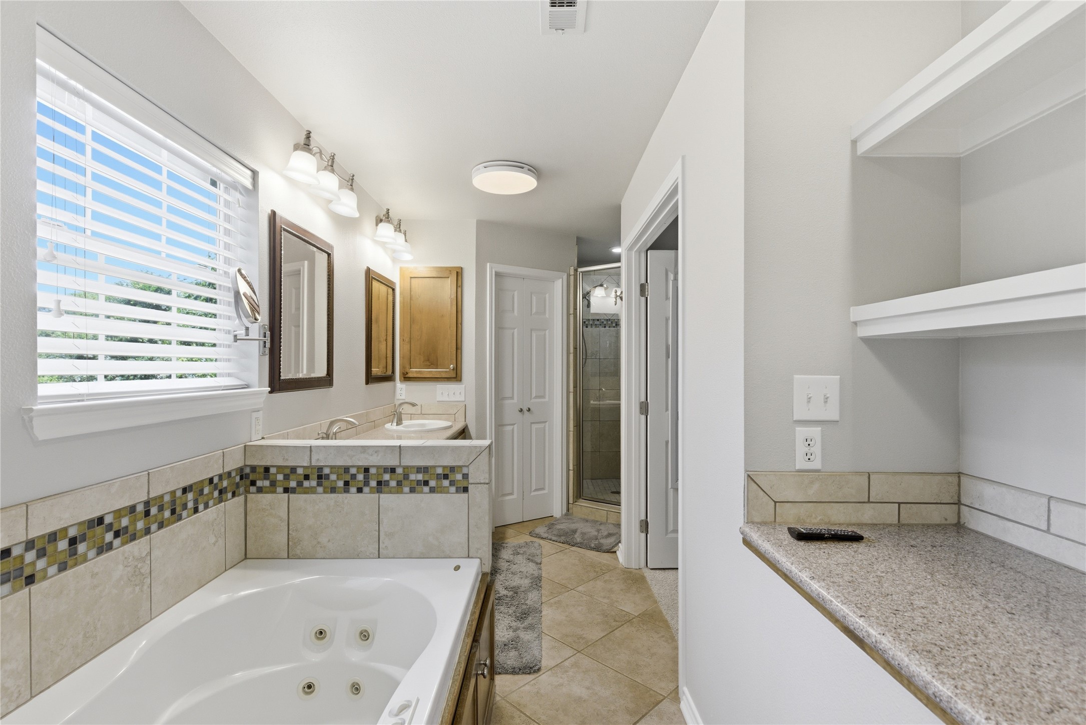 1204 Orlando Road Austin, TX 78733 - Photo 11 of 40 Relax in this primary bathroom featuring a jetted tub and dual vanity.