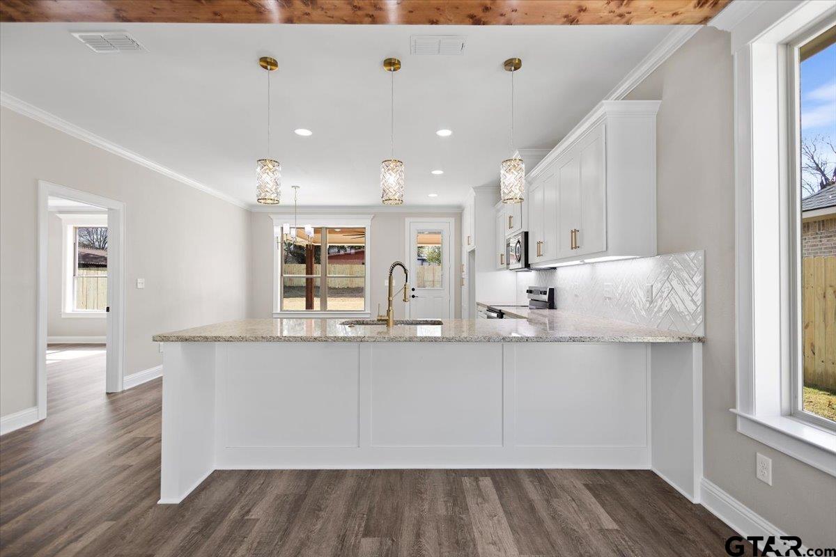 528 West 32nd Street Tyler, TX 75702 - Photo 22 of 29 a kitchen with stainless steel appliances granite countertop a white cabinets and wooden floor