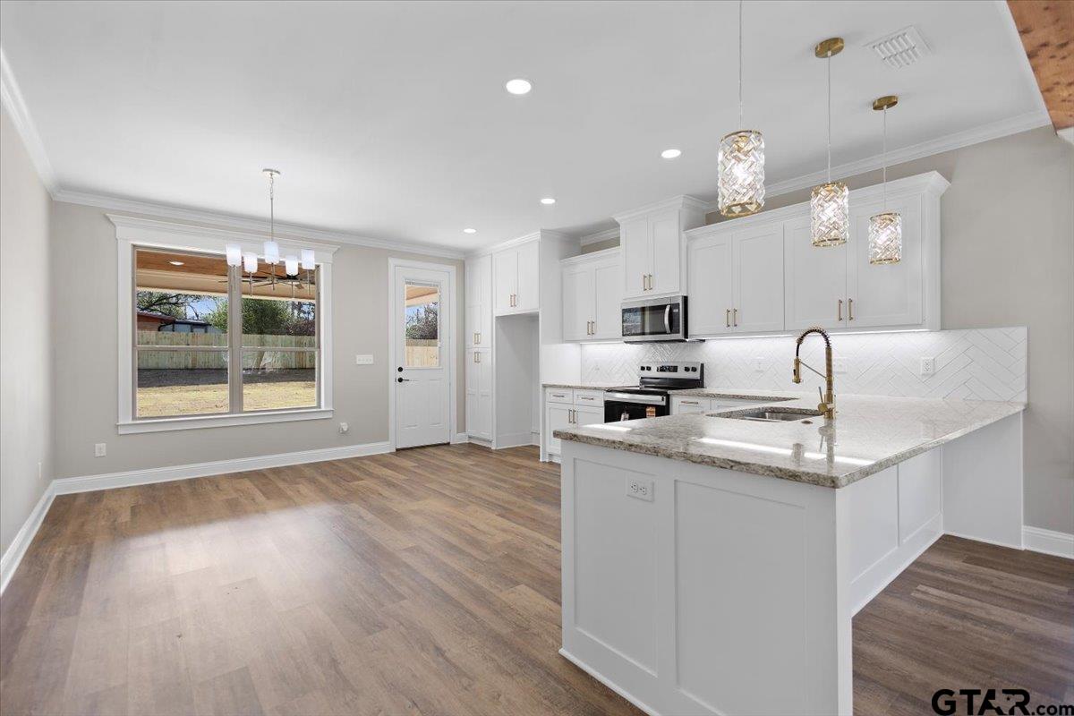 528 West 32nd Street Tyler, TX 75702 - Photo 24 of 29 a kitchen with stainless steel appliances granite countertop a sink cabinets and wooden floor