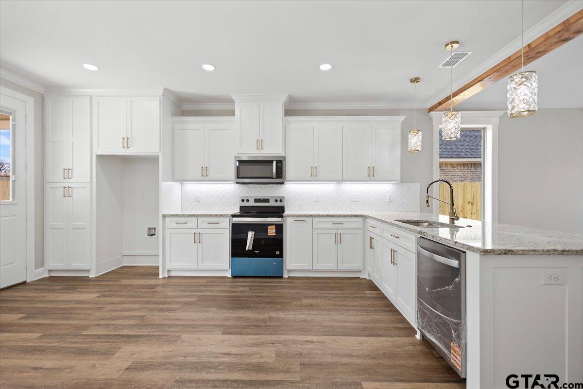 528 West 32nd Street Tyler, TX 75702 - Photo 25 of 29 a kitchen with granite countertop white cabinets and stainless steel appliances
