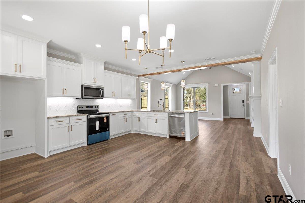 528 West 32nd Street Tyler, TX 75702 - Photo 3 of 29 a large kitchen with cabinets wooden floor and stainless steel appliances