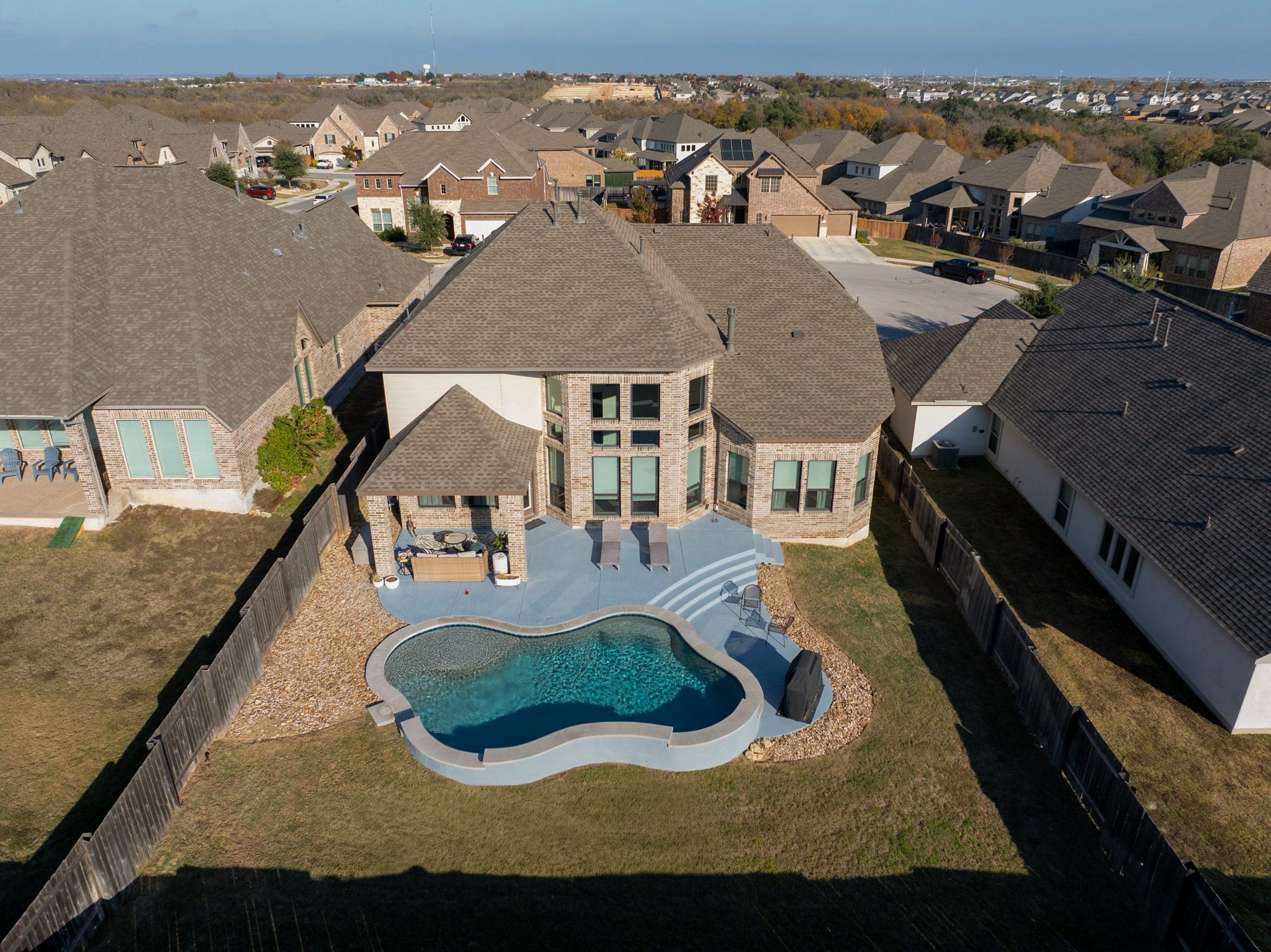 304 Wavy Cattail Cove Georgetown, TX 78626 - Photo 26 of 29 Rear view of house featuring a patio area, a fenced backyard, a residential view, and brick siding