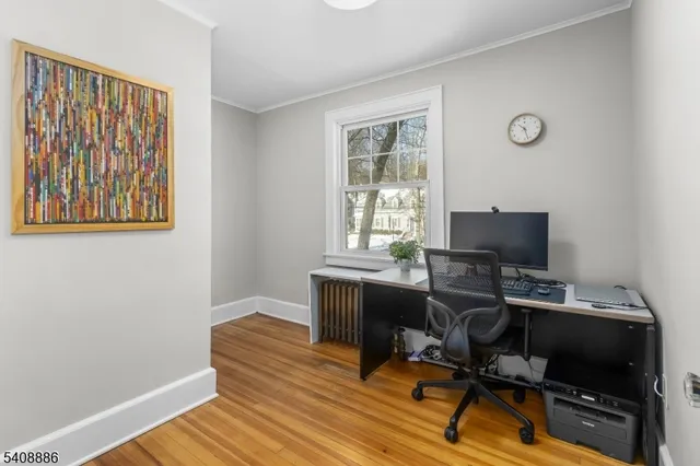 a view of a workspace with furniture and a window