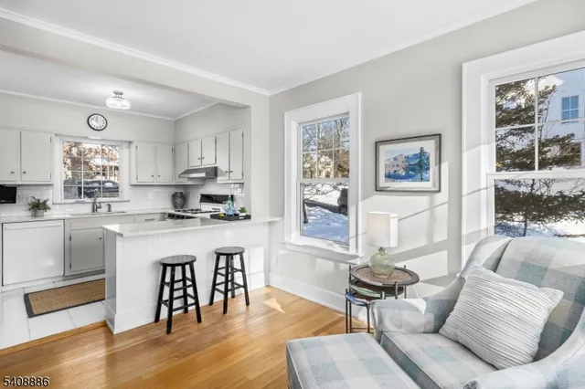 a living room with stainless steel appliances granite countertop furniture and a wooden floor