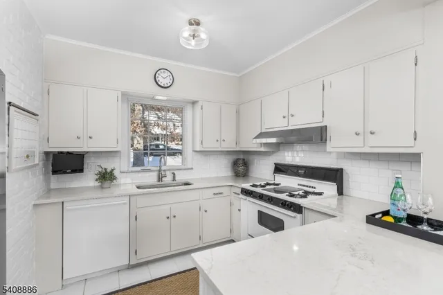 a kitchen with cabinets appliances a sink and a window