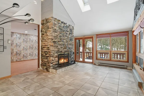 a view of an empty room with a fireplace and a window
