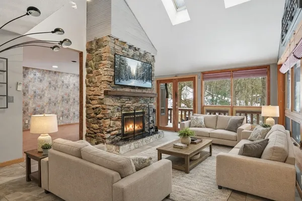 a living room with furniture a flat screen tv and a fireplace