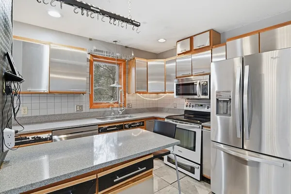 a kitchen with stainless steel appliances a refrigerator sink and microwave