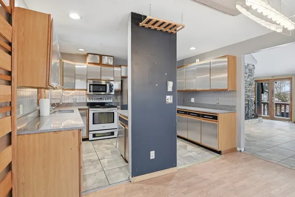 a kitchen with stainless steel appliances kitchen island granite countertop a stove a sink and a refrigerator